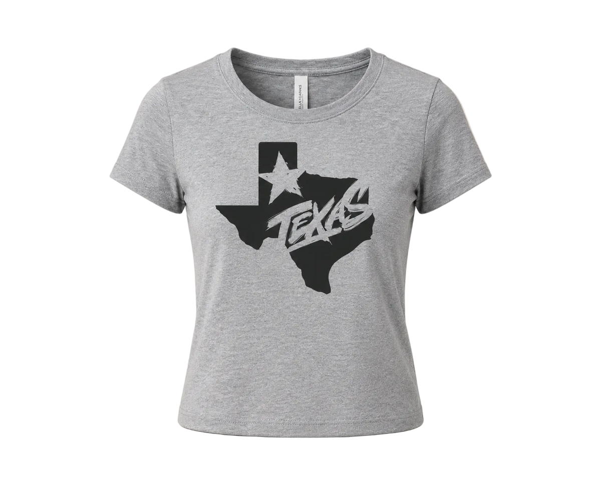 A heather gray short-sleeve t-shirt with a black graphic of the state of Texas containing the word 'TEXAS' in a stylized font, displayed on a neutral beige background.