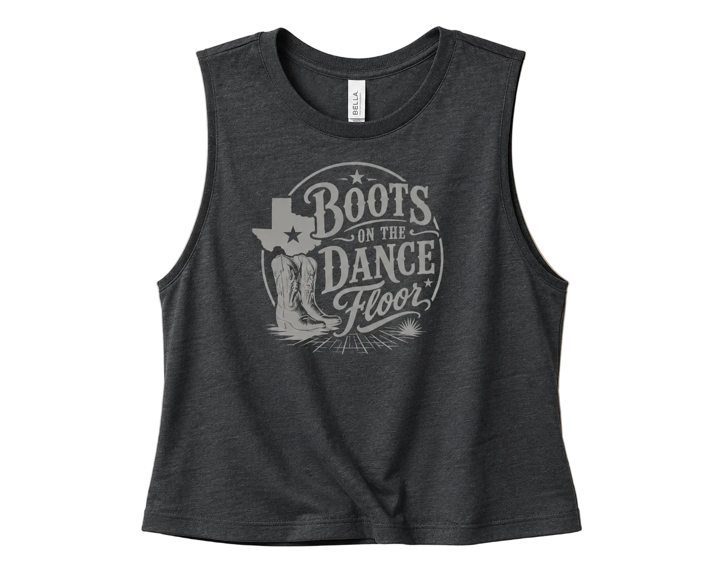 A dark heather gray sleeveless crop top with a distressed light gray graphic reading 'Boots on the Dance Floor' and a Texas-shaped boot design, shown on a solid beige background.