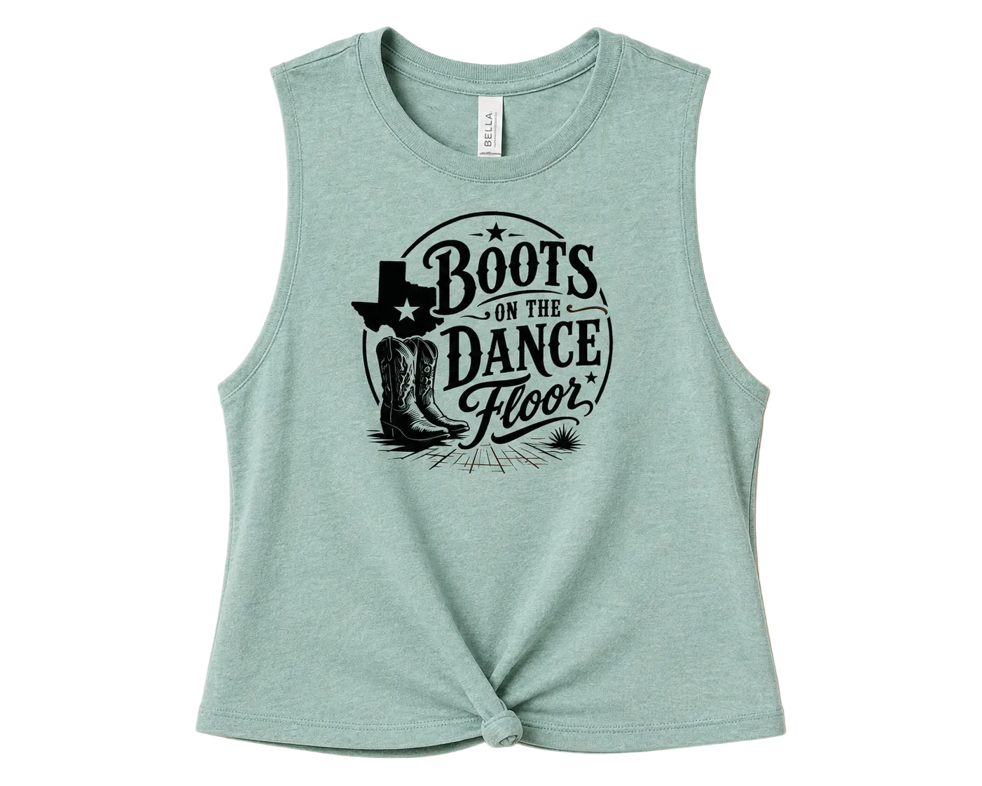 A sleeveless heathered mint green crop top with a black graphic print reading 'Boots on the Dance Floor' featuring cowboy boots and a Texas state silhouette, styled with a front knot detail against a solid peach background.